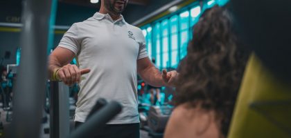 Sesión de entrenamiento en el gimnasio con un entrenador personal, enfocada en el rendimiento y el bienestar físico.