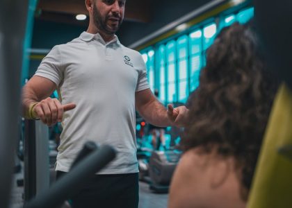Sesión de entrenamiento en el gimnasio con un entrenador personal, enfocada en el rendimiento y el bienestar físico.